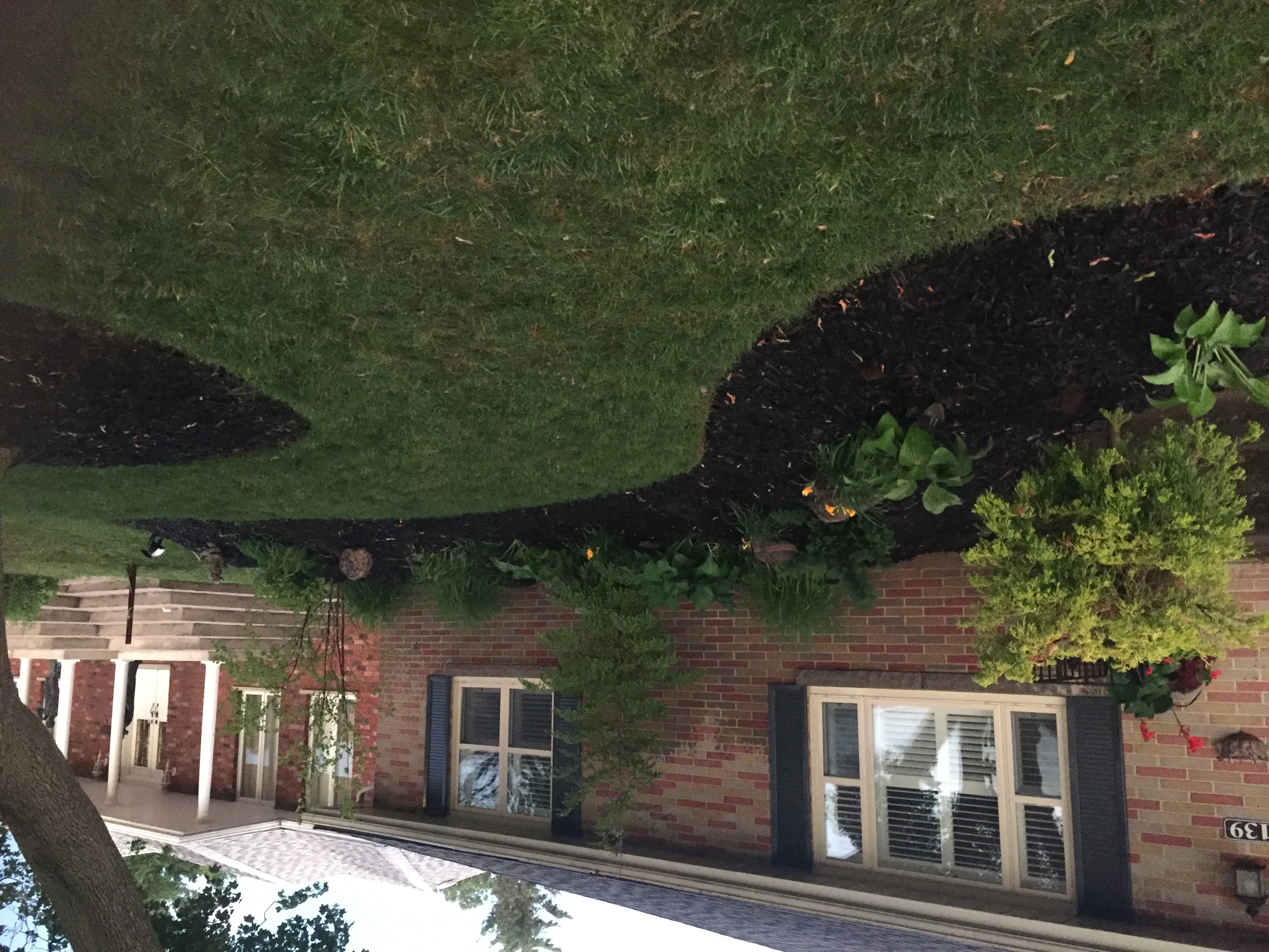 Aerial view of brick home with landscaped walkway and entrance by Martin Services