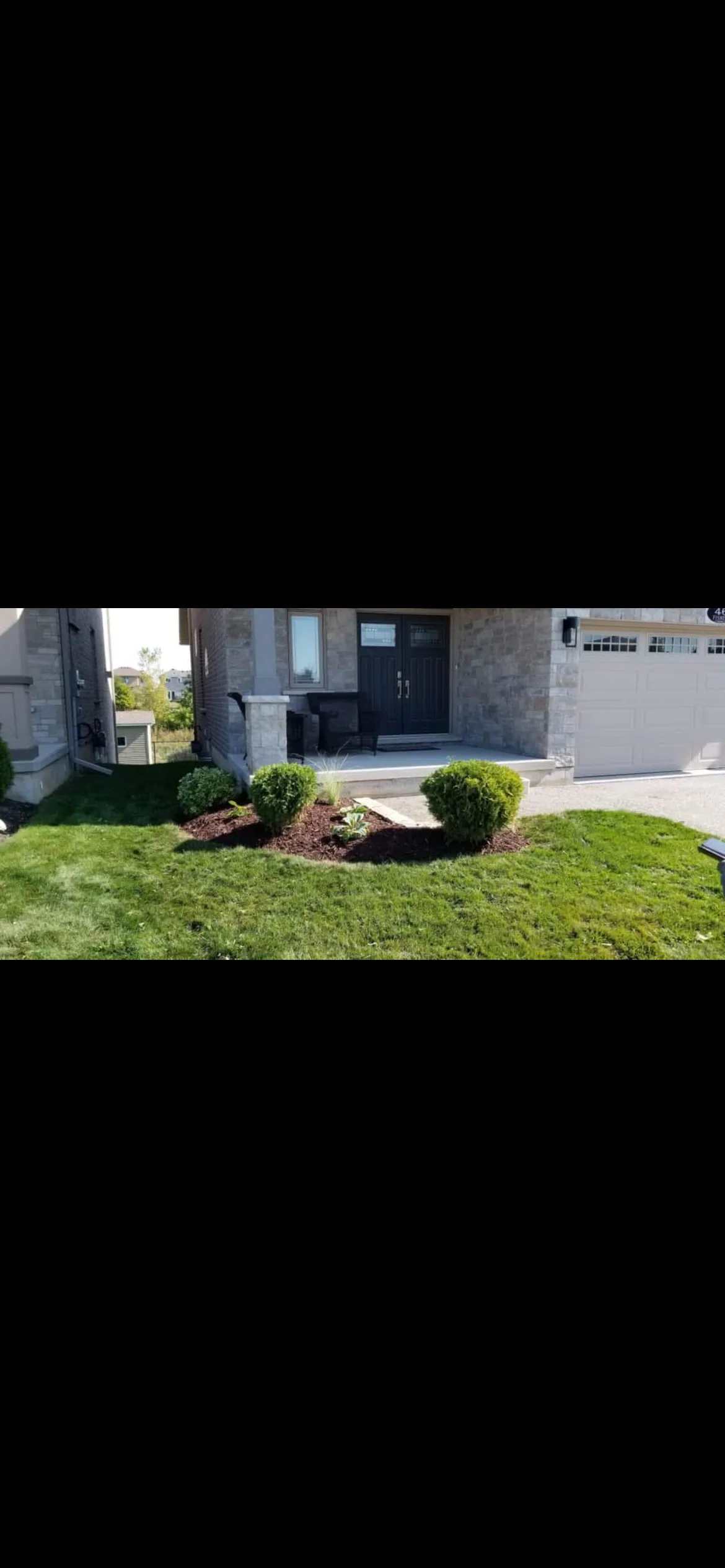 Rounded boxwood shrubs professionally planted at front entry by Martin Services in Powassan, Ontario