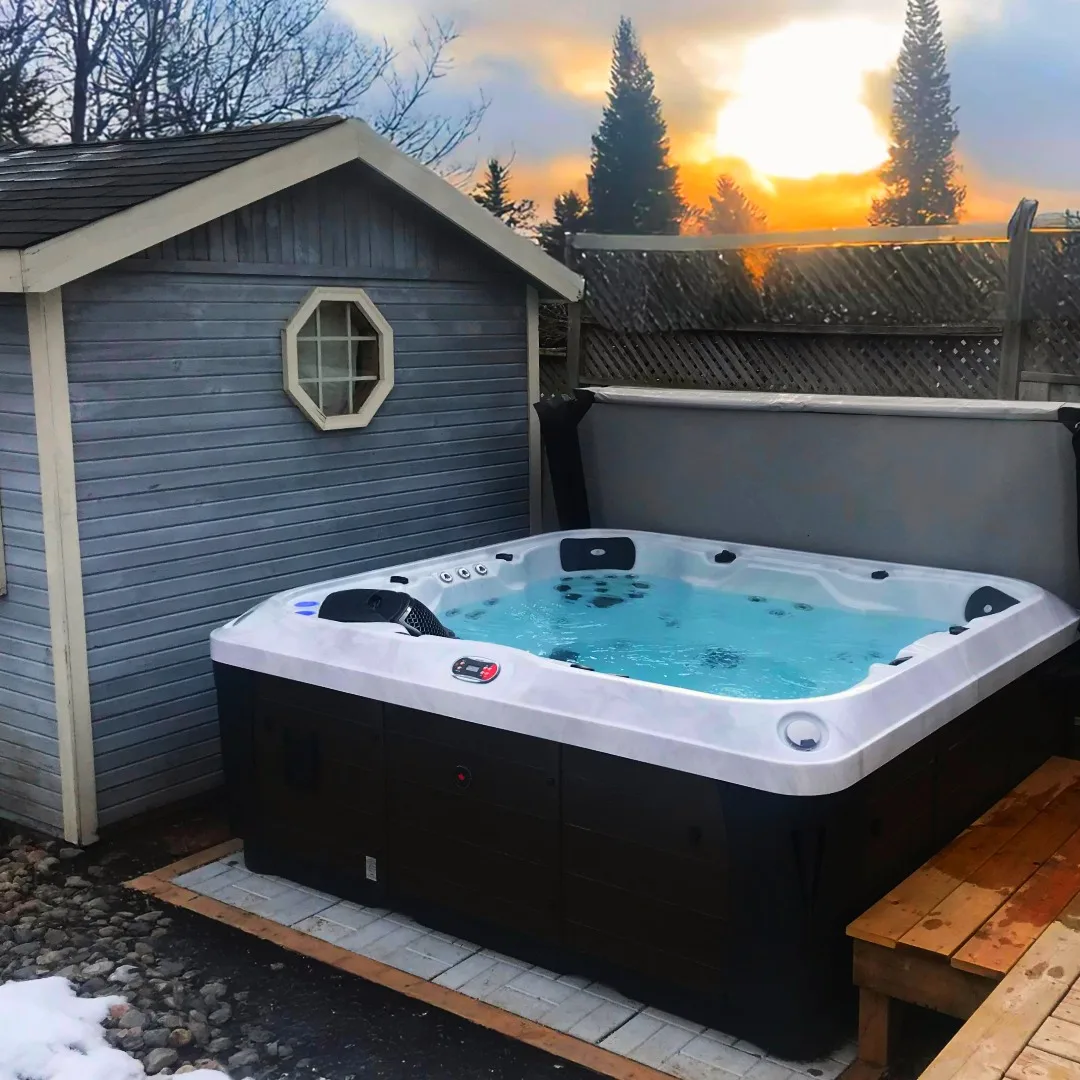 Hot tub professionally installed beside backyard shed at sunset — Martin Services delivery in Ontario