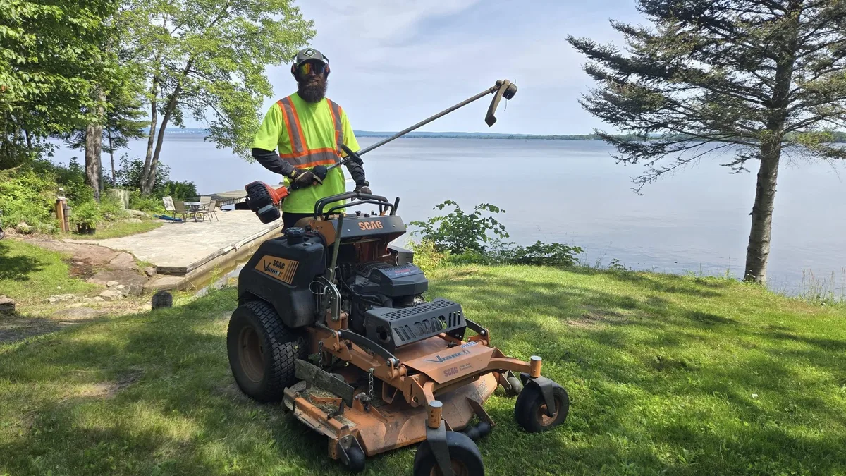 Martin Services providing professional lawn mowing near a lakefront property in the Corbeil area, Ontario