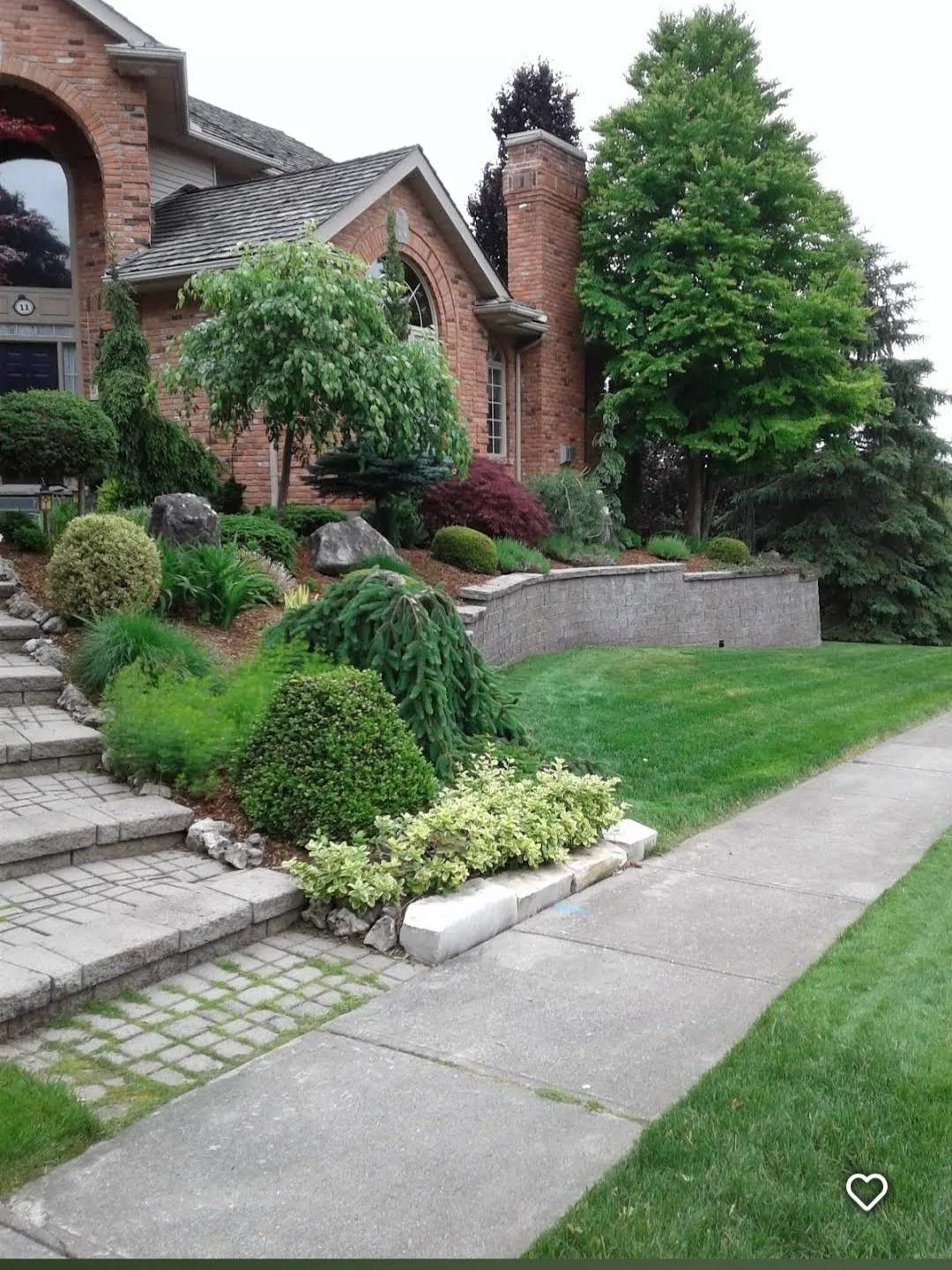 Well-maintained front yard with pruned trees near North Bay, Ontario