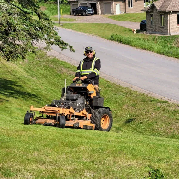 Martin Services crew member on a Scag zero-turn mower, maintaining a residential property in Northern Ontario